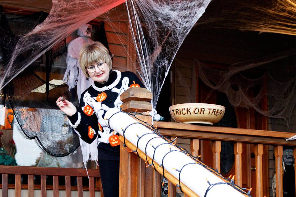 Micky Lacewell gears up to aim some treats down a remote candy delivery system to her granddaughters. Her husband, Kirk Lacewell, built the candy chute on the porch of their Langley home as a way to hand out treats from a safe distance on Halloween night. File photo by Kira Erickson