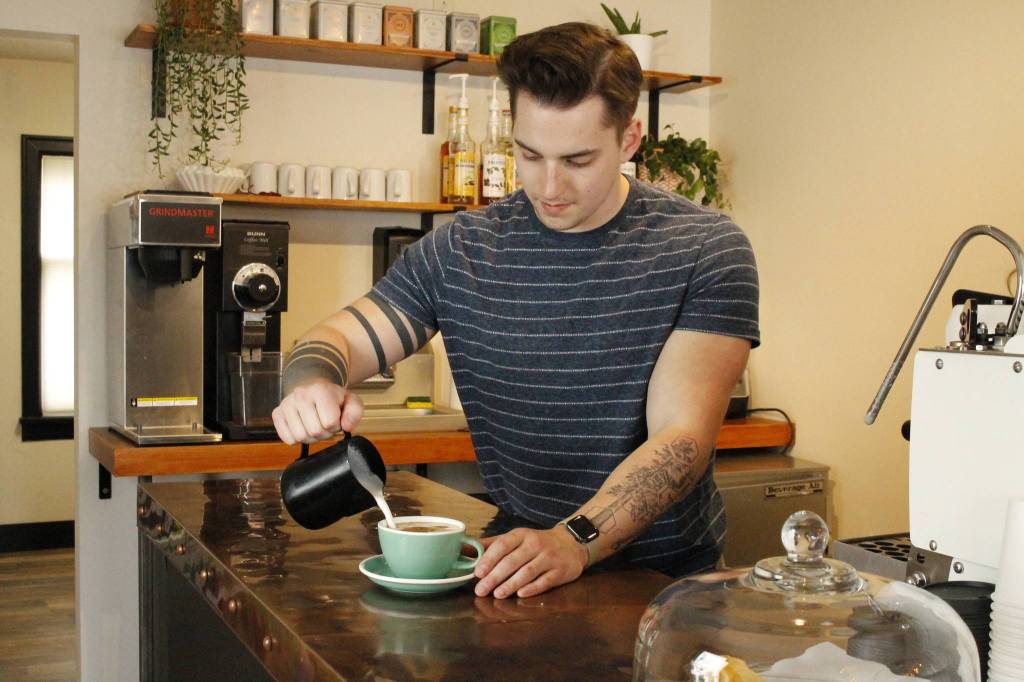 Newton pours a cup of coffee.