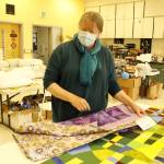 Luanne Seymour shows a few different-sized quilts that the group she helped start, Whidbey Blanket Makers, recently made. (Photos by Kira Erickson/South Whidbey Record)