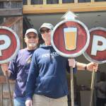 Artist Mark Wacker, at left, and Randy Urquhart, one of the partners on the Freeland Taproom venture, hold signs created for the new establishment. (Photo by Jessie Stensland/South Whidbey Record)