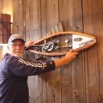 Artist Mark Wacker hangs a fish ornament he created for the taproom barn. (Photo by Jessie Stensland/South Whidbey Record)