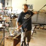 Don Singleton of Island Art Glass makes a stem for a glass-blown lily. (Photo by Kira Erickson/South Whidbey Record)