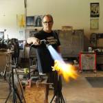 Singleton uses the flame of a gas torch to heat up a glass-blown lily. (Photo by Kira Erickson/South Whidbey Record)