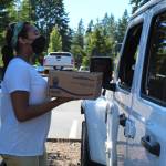 Taylor Moore delivers a smoothie bowl to a customer outside of Pickles Deli in Clinton. (Photo by Karina Andrew/Whidbey News-Times)