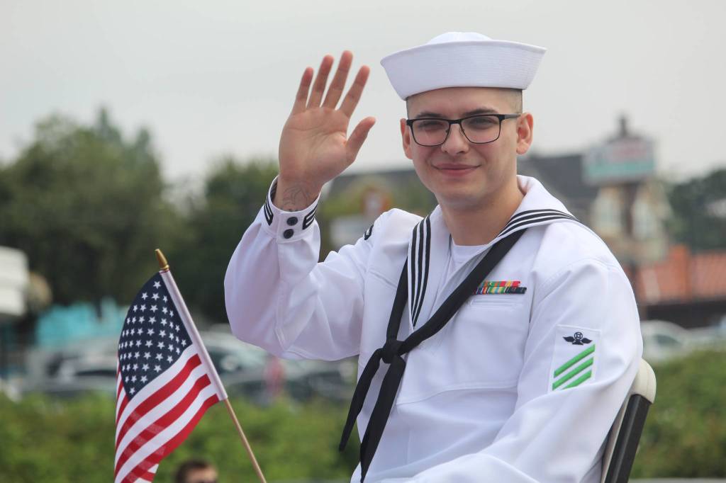A sailor waves at the crowd. (Photo by Karina Andrew/Whidbey News-Times)