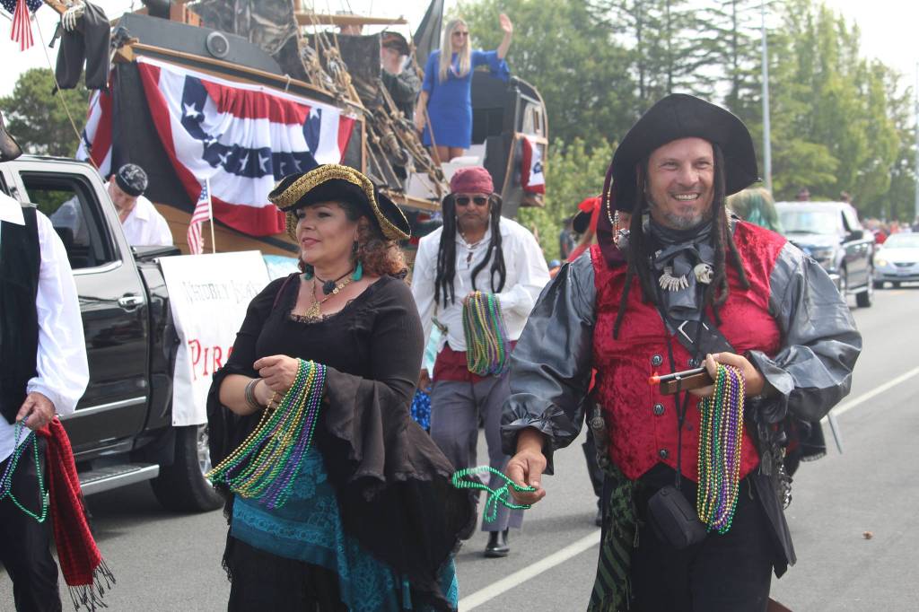 People dressed as pirates pass out beads to the crowd. (Photo by Karina Andrew/Whidbey News-Times)