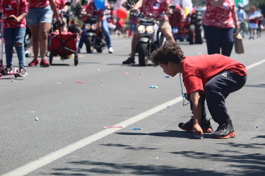 A youngster collects candy tossed to the crowd by parade participants. (Photo by Karina Andrew/Whidbey News-Times)