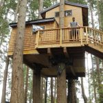 Max Lindsay-Thorsen stands on the deck of Treehouse Whidbey, a recently finished vacation rental in Clinton. On a windy day, guests can feel the house moving with the trees. (Photo by Kira Erickson)
