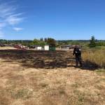 Navy photo
NAS Whidbey Fire Inspector Zach Walker looks at the damage of a small fire at a yard in military housing in Crescent Harbor Tuesday.
