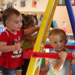 Alice Dugger, 2, colors while Wyatt Wing, 2, plays under the easel in the toddler class at Little Oaks Preschool. (Karina Andrew/Whidbey News-Times)