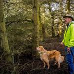 Bill Headridge and his dog Ginger appear delighted by the discovery of a Douglas squirrel during a late February walk at Admiralty Inlet Preserve, protected by the Whidbey Camano Land Trust. (Photo by Pam Headridge)