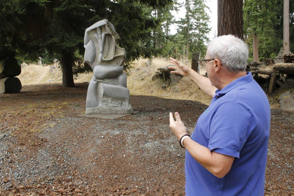 Burt Beusch, executive director of the Cloudstone Foundation, points out one of many sculptures in the Cloudstone Sculpture Park. (Photo by Kira Erickson/South Whidbey Record)