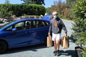 Andrew Curtis drops off groceries at a home in Clinton on a delivery run for Whidbey Deliveries. (Photo by Karina Andrew/Whidbey News-Times)