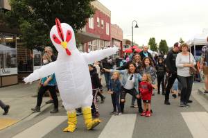Karina Andrew/Whidbey News Group
Oak Harbor's famous chicken dances with the crowds at the Oak Harbor Music Festival Saturday. Ever the trendsetter, it appears a flock of fans have copied his signature pose while he struts about the town during the multi-day music festival.