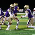 Oak Harbor High School senior Kaito White, left, hands off the ball to sophomore Brody Snyder during the homecoming game Sept. 17 against Stanwood High School. The Wildcats lost to the Spartans 34-14. (Photo by John Fisken)