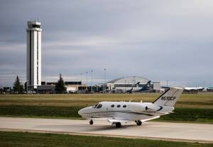 A private plane taxis past the Paine Field tower and passenger terminal on Wednesday in Everett. (Olivia Vanni / The Herald)