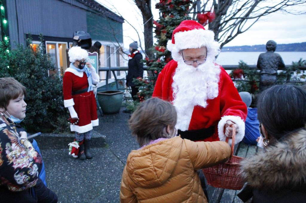 Photo by Kira Erickson/South Whidbey Record
Santa Claus, played this year by Mark Stewart Cassidy, handed out gobs of candy canes to a crowd of children Saturday evening in Langley during the citys annual Tree Lighting Ceremony. The big jolly red man traveled to three different Christmas trees in the Village by the Seas downtown corridor.