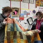Photo by Karina Andrew/Whidbey News-Times
Maura Whittaker, left, was finally allowed to return to the U.S. to retrieve a quilt she had dropped off with Debra Staley at the Quilters Workshop before the pandemic. Whittaker made the quilt out of fabric from a book of upholstery and curtain samples.