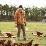 Brooke Crowder visits the chicken coop. (Photo by Karina Andrew/Whidbey News Group)