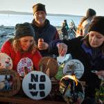 Photos by David Welton
People attending Hansens celebration of life service make shields for the boat, which contained family photographs, drawings of the Norwegian flag and other kind sentiments. Below, Michael Clyburn, left, and Ryan Kerkvliet carry the Viking boat to the waters edge at Maxwelton Beach on Saturday.