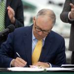 Governor Jay Inslee signs SB 5974 into law during a bill signing Friday, March 25, 2022, outside the ferry terminal in Mukilteo, Washington. (Ryan Berry / The Herald)