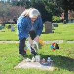 Mirria Gonzalez places ceramic angel wings on Deborah Palmers grave. She said she occasionally finds evidence that other people have also visited the site. (Photo by Jessie Stensland/Whidbey News-Times)