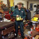 Photo by David Welton
With just about every tool and part imaginable in his shed, Gallion holds one of the chainsaws he is repairing.