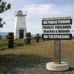 A sign and rope fences warn the public of Bush Point Lighthouse’s private status Thursday, April 7, 2022, near Freeland, Washington. (Ryan Berry / The Herald)