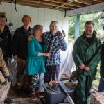 Beverly and Bob Pearce, at center, and the Heart Hammers work crew take a moment to get out of the wet weather.(Photo by David Welton)