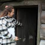 Reserve education and outreach coordinator Jordan Belcher opens the door of the blockhouse next to the Jacob and Sarah Ebey House. (Photo by Karina Andrew/Whidbey News-Times)