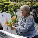 Photo by Kira Erickson/South Whidbey Record
Deborah Montgomerie traces a tulip painted on her chair, which is titled Tulip Mania after a period in history where prices of tulip bulbs soared in Holland.
