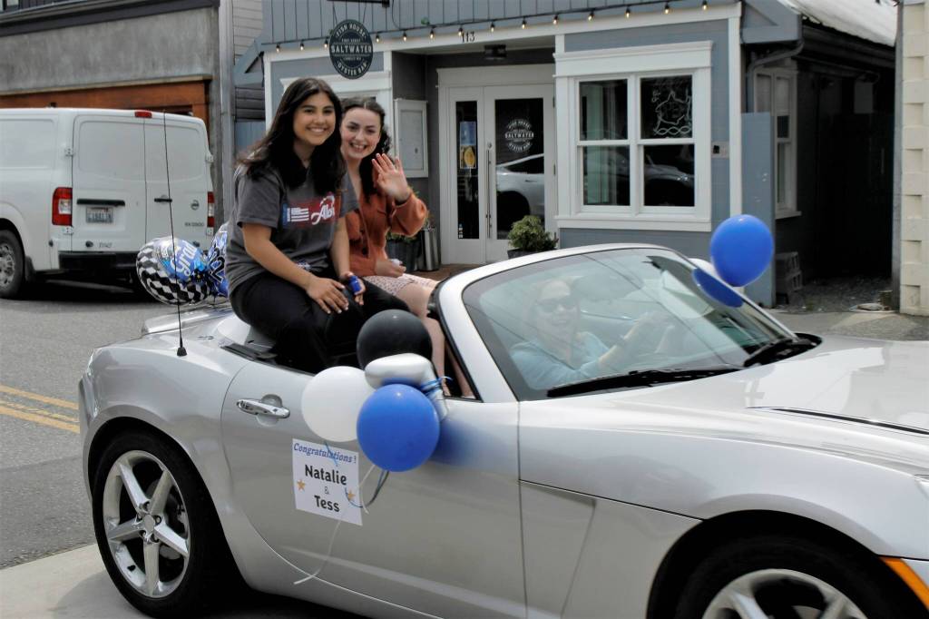 Natalie Monetti and Tess Patty-Caldwell wave from the backseat of a car driven in the parade Wednesday afternoon. (Photo by Kira Erickson/South Whidbey Record)