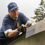 Jim Rogers of Rotary Club of Whidbey Westside reroofs a storage shed at the House of Hope.