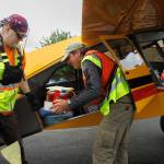 Volunteers unload food donations from an airplane. (Photo By David Welton)