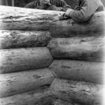 Washington State Archives photo
Two crew members stand behind the walls of a log house under construction in the 1930s.