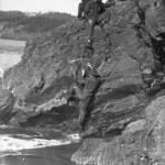 Civilian Conservation Corps members climb a rock in Deception Pass State Park in November 1933.