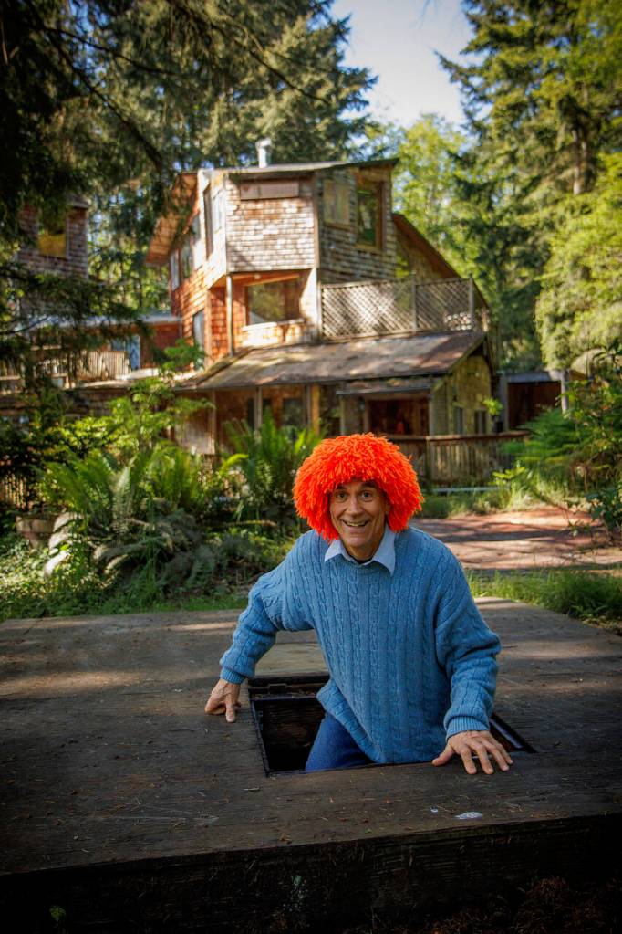 Dean Petrich appears from a secret tunnel at his clown house in Freeland. The home, which he built himself, is made entirely of recycled materials.