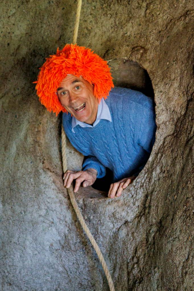 Dean Petrich appears from a secret tunnel at his clown house in Freeland. The home, which he built himself, is made entirely of recycled materials.
