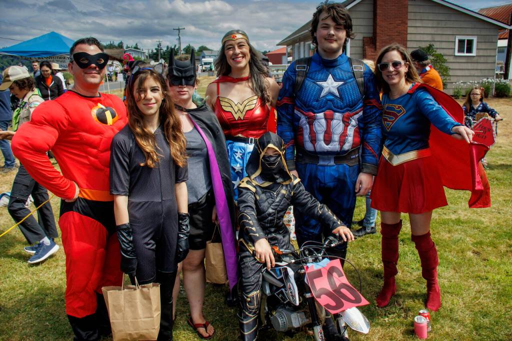 A family of superheroes keep an eye out for trouble during the Maxwelton parade.