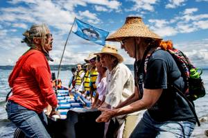Photo by David Welton
The Blue Heron Canoe Family pulls a canoe up onto the beach after arriving at Sandy Point on Whidbey Island.