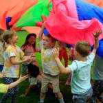 Kids play under a parachute at Family Story Time at Castle Park in Langley July 6. (Photo by David Welton)