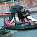 Angelina Jimmy, 6, and Brandon Cayou drive together in a go-kart at the Blue Fox Drive-In Theater in Oak Harbor. (Ryan Berry / The Herald)