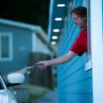 People pay at the window for movie tickets at the Blue Fox Drive-In Theater. (Ryan Berry / The Herald)