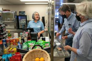 Maria Rios, a galley cashier, helps Frank and Fran Butler, of Washington, D.C., with food purchases aboard the Suquamish ferry between Mukilteo and Clinton. The galley is among several reopened after being closed over two years due to the pandemic. The galley of the Tokitae, the other boat on the Mukilteo-Clinton route, remains closed for now. (Ryan Berry / The Herald)