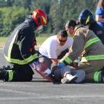 First responders practice loading a wounded patient onto a stretcher at Outlying Field Coupeville.
