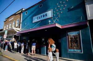 People line up on First Street for the doors to open at The Clyde Theater in Langley on Whidbey Island. The movie house opened in 1937. (Olivia Vanni / The Herald)