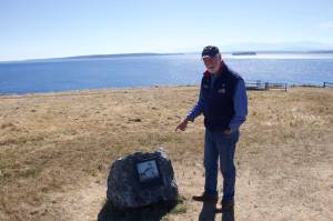Photo by Rachel Rosen/Whidbey News-Times
Wayne Clark, a volunteer docent at Fort Casey State Park, stands next to the the new boulder and plaque that marks the spot of the original lighthouse at Admiralty Head.