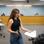 Photo by David Welton
Annie Philp distributes materials related to the United Student Leaders plea for county commissioners to adopt a climate emergency declaration during a meeting Tuesday.