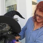 Photos by Karina Andrew/Whidbey News-Times
Mel Rodman makes some adjustments to the human-sized crow that represents her business, Crows Roost, in her Scarecrow Trail display.