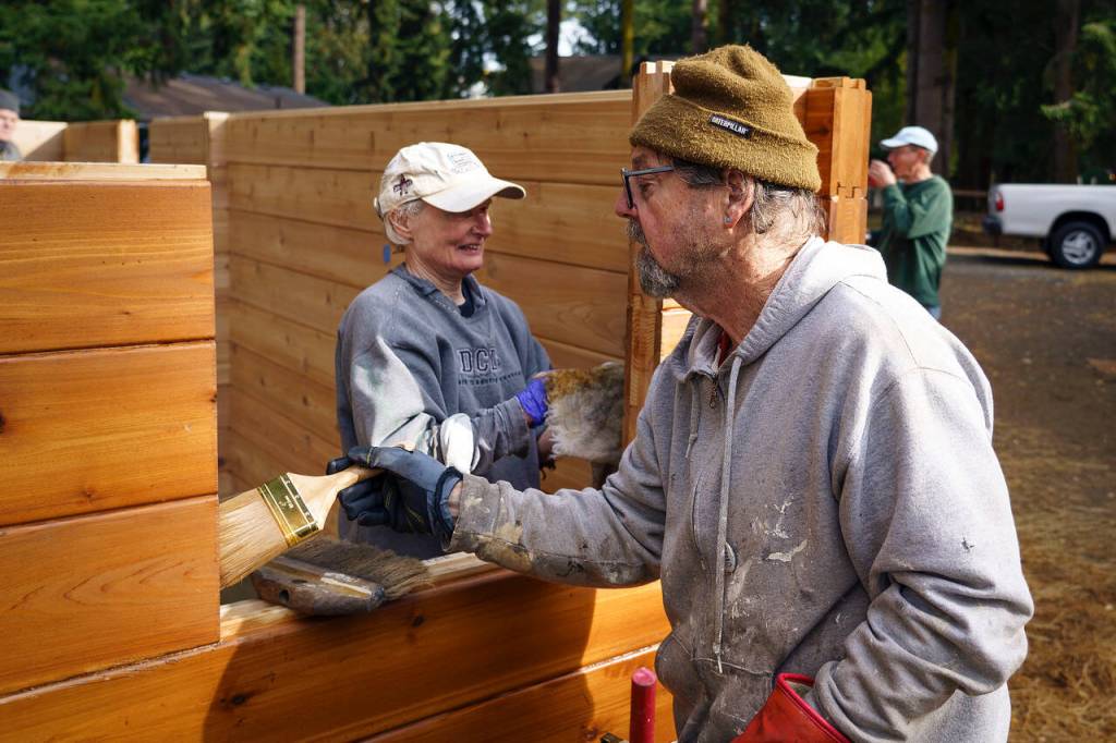 Photo by David Welton
Betsy McCullough and Clancy Dunigan, both of Langley United Methodist Church, work on staining the cedar tiny home.
